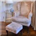 F13. Upholstered wing chair with matching footstool.  